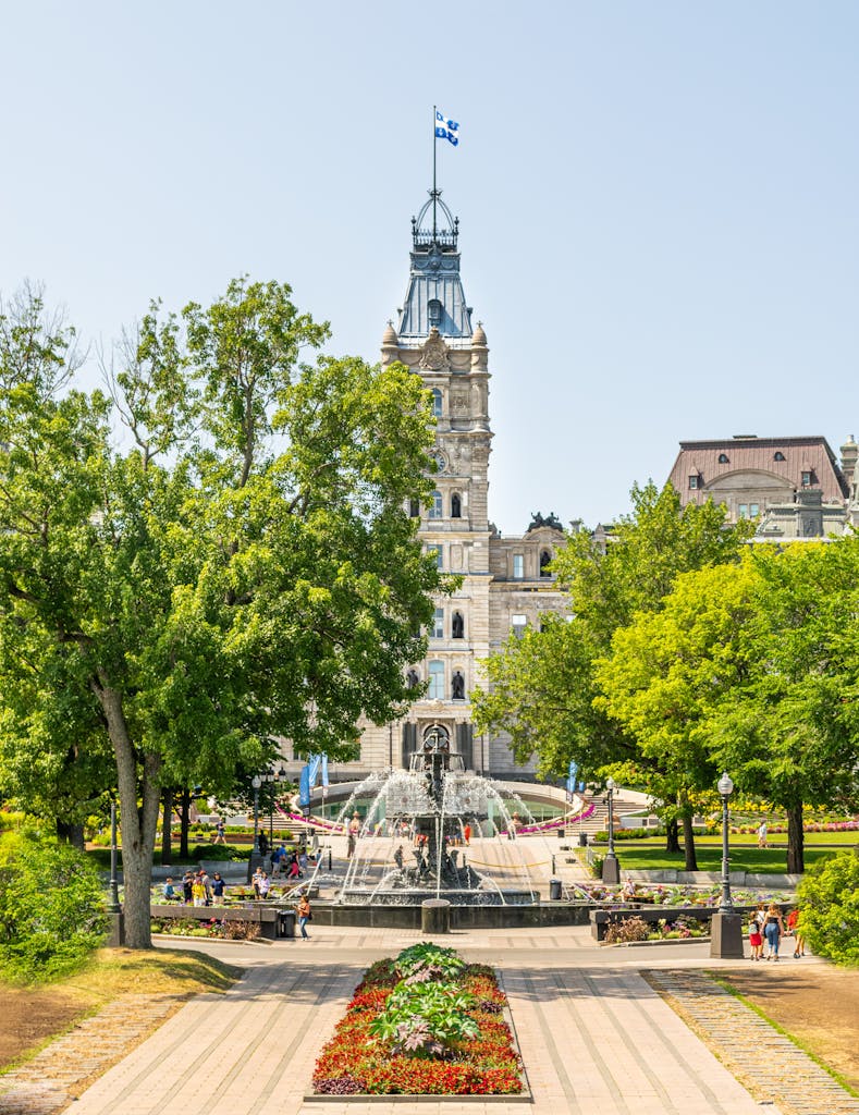 A scenic view of the Quebec City Parliament Building and Fontaine de Tourny during a sunny day.