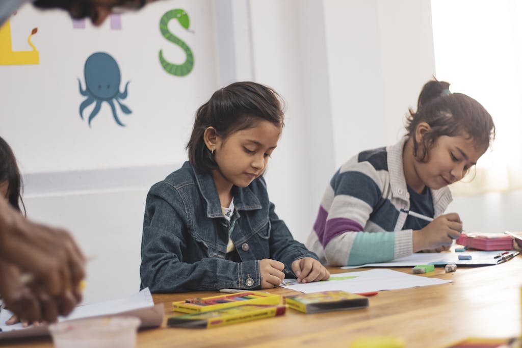 Young girls engaging in creative drawing activities in an Indian classroom setting.